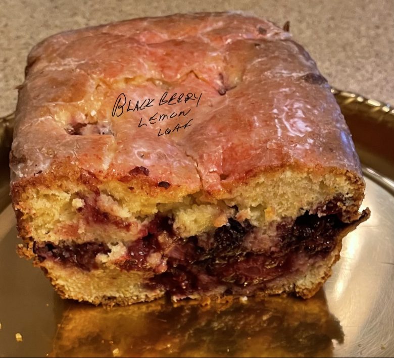 Blackberry lemon loaf with a glazed top and berry-filled center