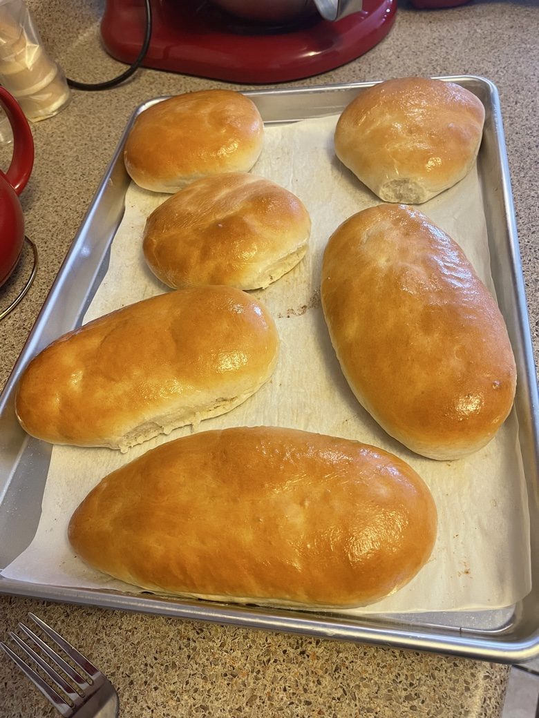Six golden buns on a sheet pan
