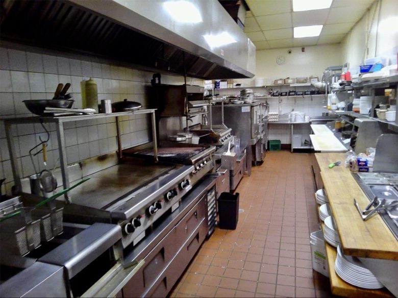 Commercial kitchen with the cooking line, ovens, and pass