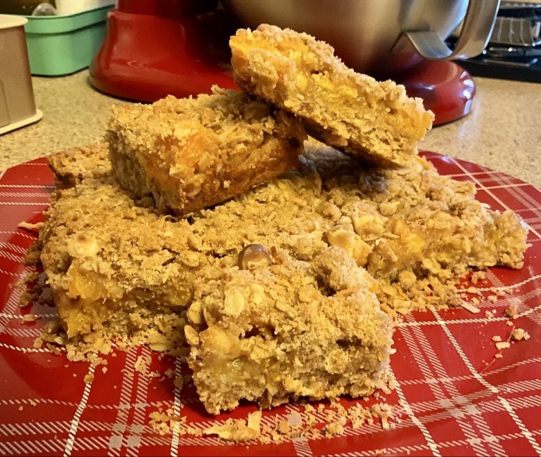 Orange white chocolate crumble bars on a red plate