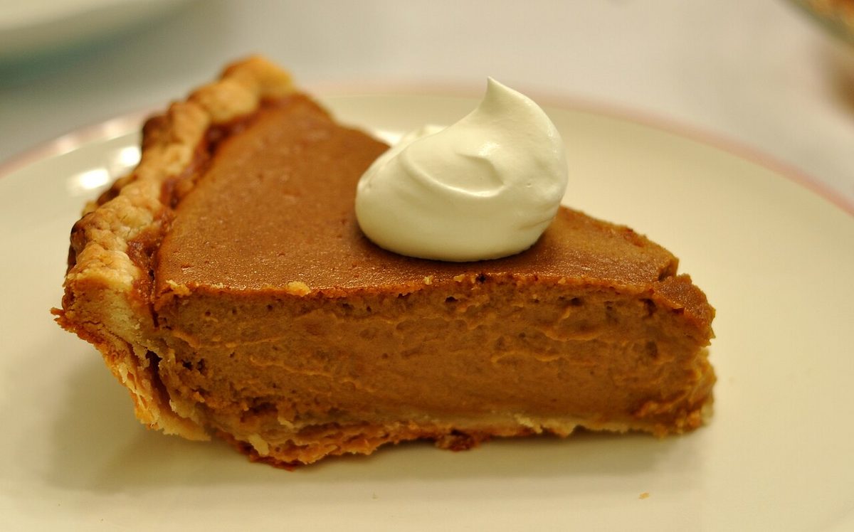 Slice of pumpkin pie topped with whipped cream