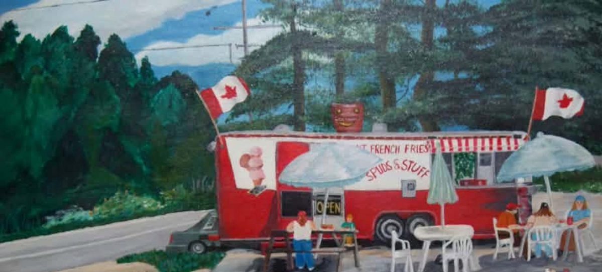 Painting of Bob's red SPUDS & STUFF fry trailer with Canadian flags, customers at tables, and pine trees