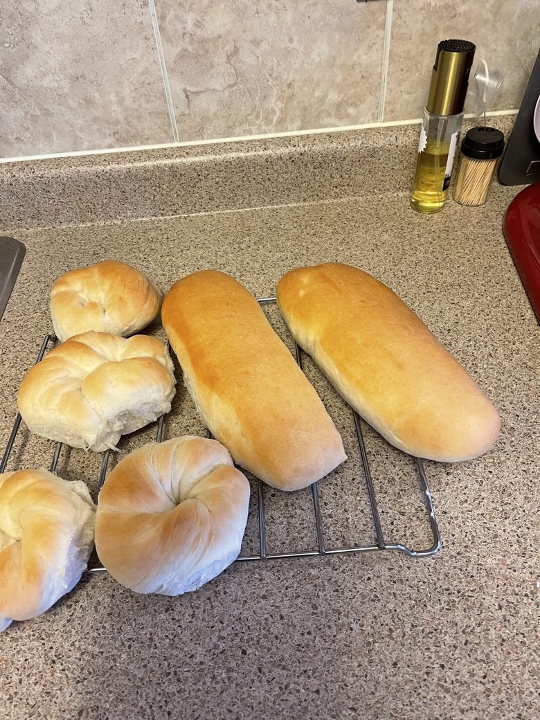 Sub buns and knotted rolls cooling on a rack